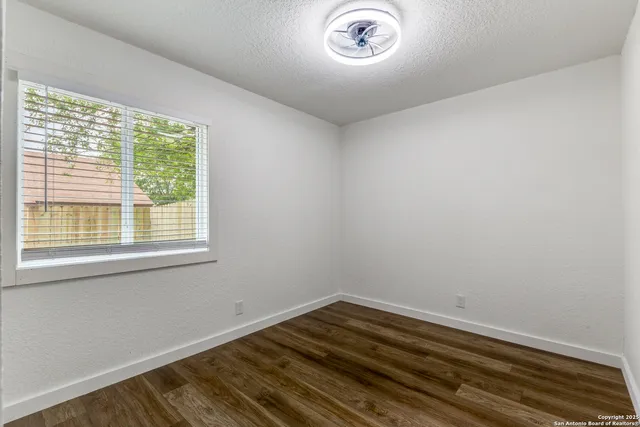 a view of a room with wooden floor and a window
