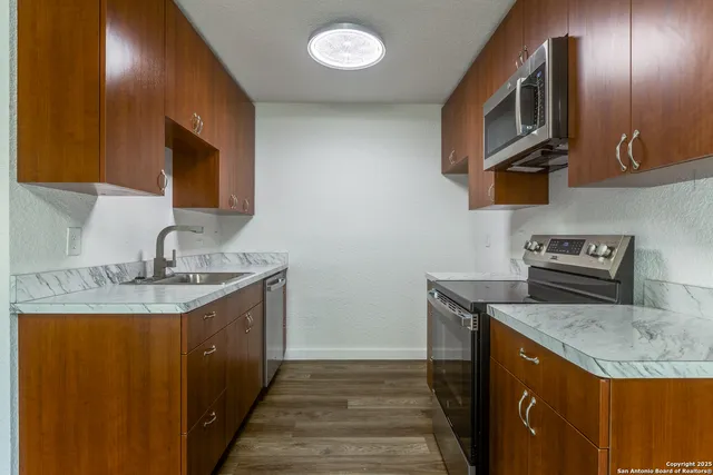 a kitchen with stainless steel appliances granite countertop a sink a stove and a microwave