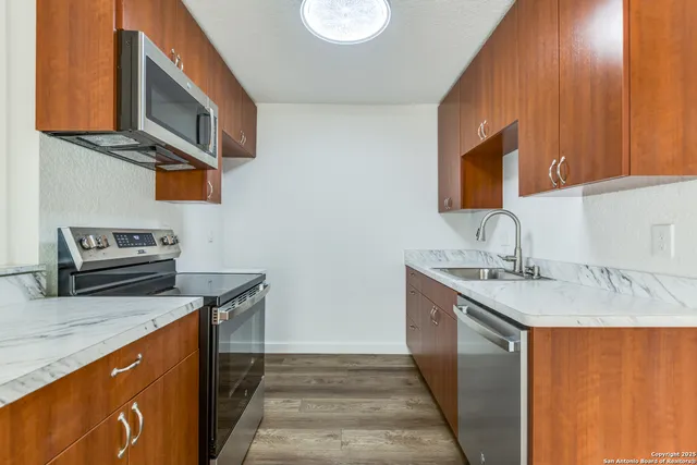 a kitchen with stainless steel appliances granite countertop a sink stove and cabinets