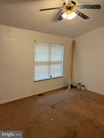 an empty room with a window and a ceiling fan