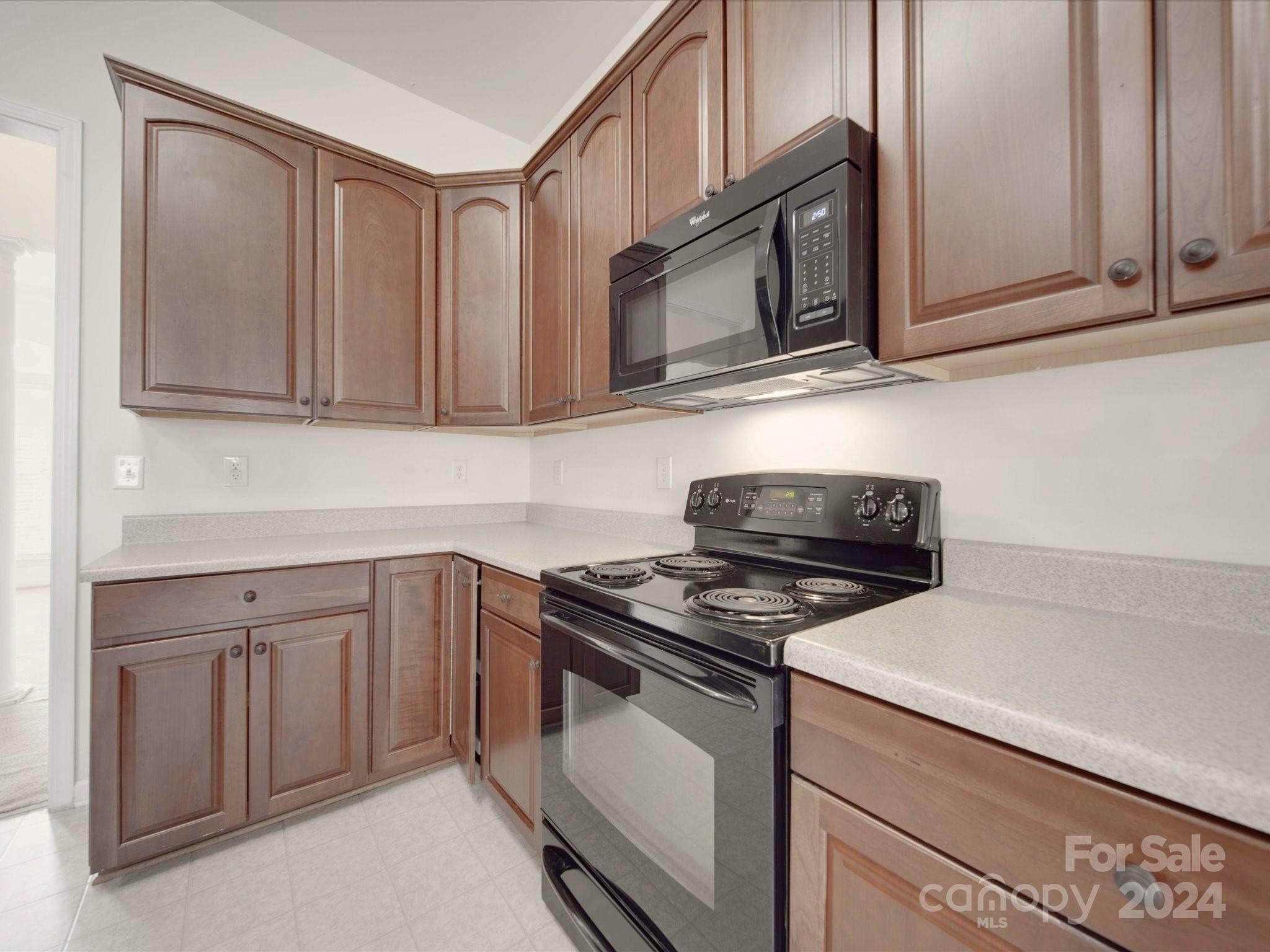 1004 Spanish Moss Road Indian Trail, NC 28079 - Photo 12 of 25 a kitchen with stainless steel appliances granite countertop white cabinets and a stove top oven