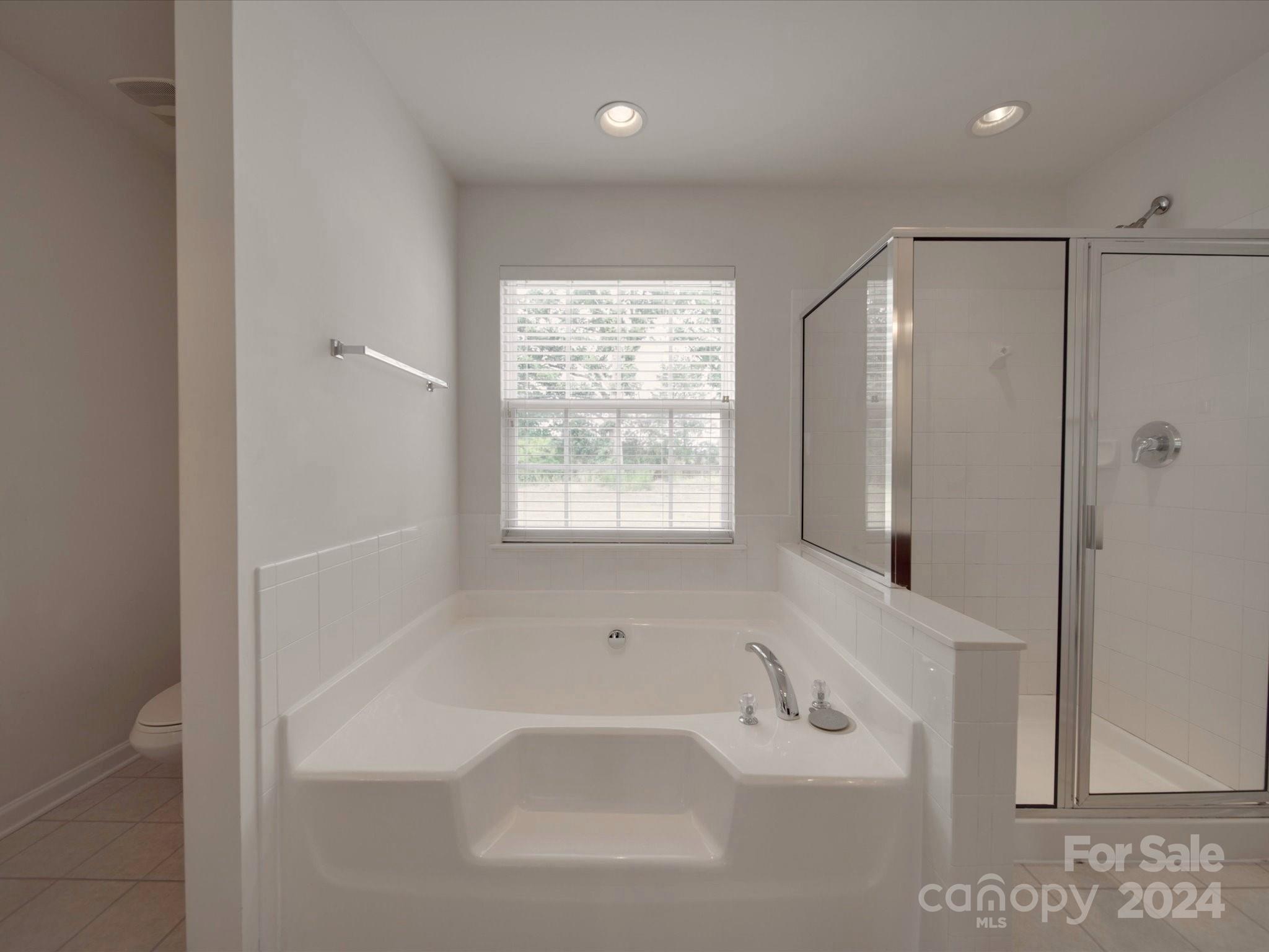 1004 Spanish Moss Road Indian Trail, NC 28079 - Photo 22 of 25 a bathroom with a bathtub a shower and a sink