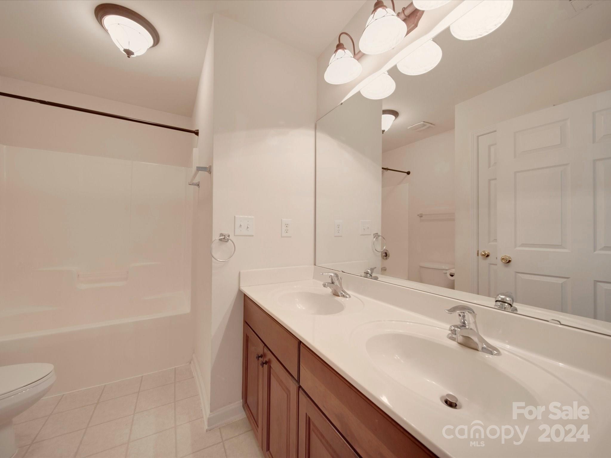 1004 Spanish Moss Road Indian Trail, NC 28079 - Photo 6 of 25 a bathroom with a sink a toilet a mirror and shower