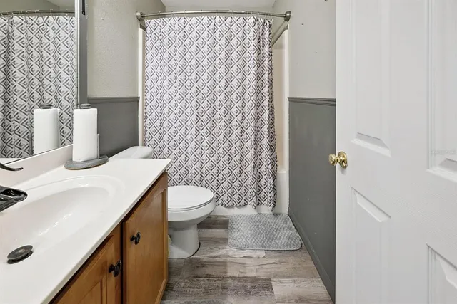 a view of backyard with wooden fence and a large trees