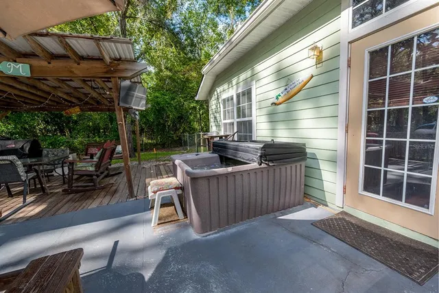 a backyard of a house with table and chairs under an umbrella