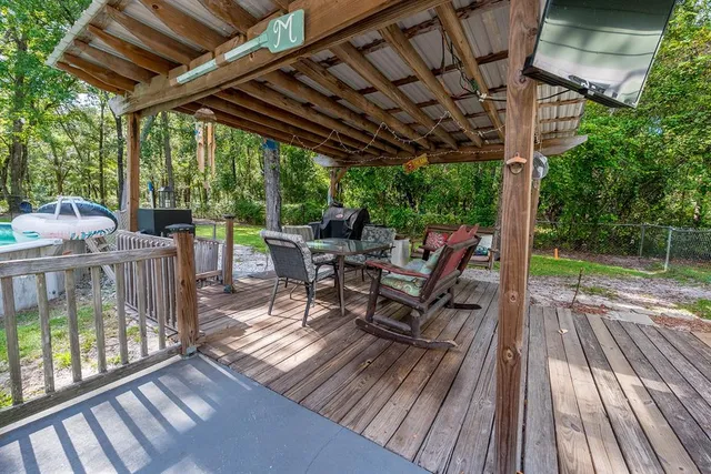 a view of a backyard with a garden and deck