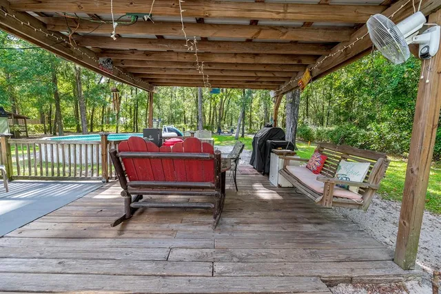 a view of backyard with wooden fence and large trees
