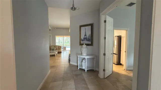 a view of a hallway with wooden floor and a living room