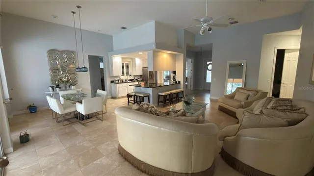 a living room with furniture a large window and a chandelier