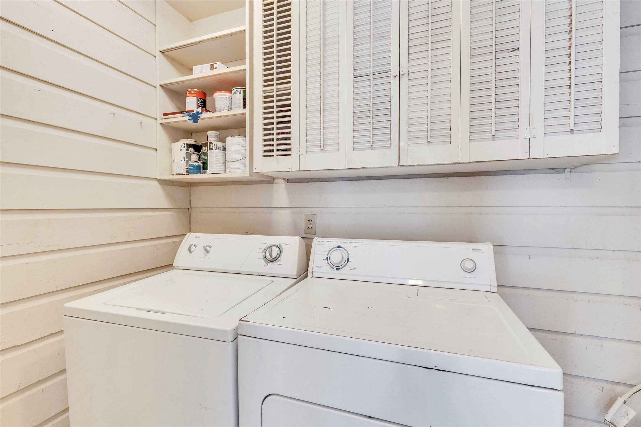 3810 Brookview Road Austin, TX 78722 - Photo 12 of 27 Functional workspace features horizontal wood-paneled walls and abundant built-in overhead storage cabinets.