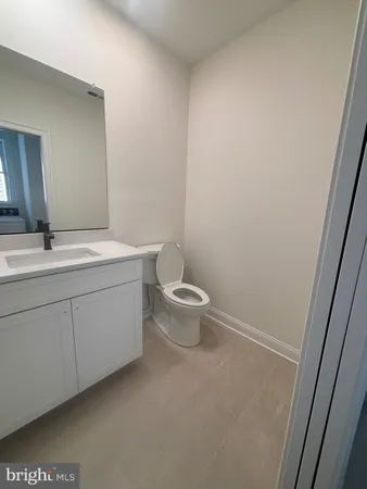 a spacious bathroom with a toilet sink and mirror