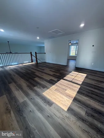 a view of a big room with wooden floor and windows