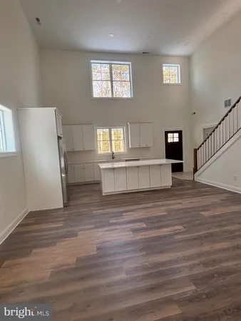 a view of kitchen and hallway with wooden floor