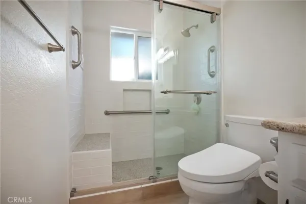 a backyard of a house with a table and chairs under an umbrella