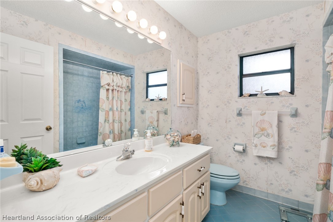 5802 Golden Road Sebring, FL 33875 - Photo 22 of 37 a bathroom with a sink mirror and a toilet