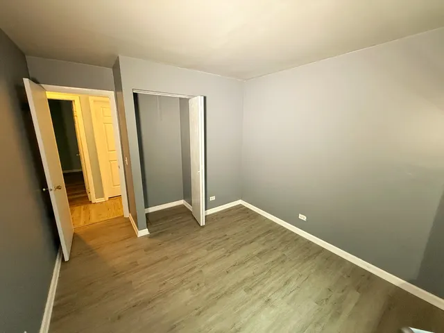 an empty room with wooden floor and window