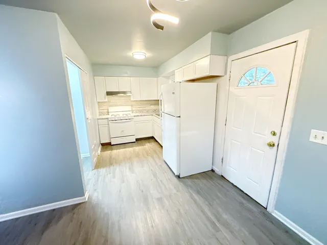 a view of a kitchen with wooden floor and a window