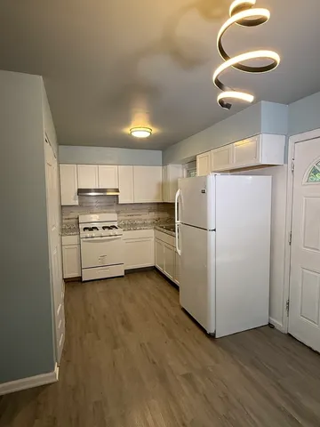a kitchen with wooden cabinets and white appliances