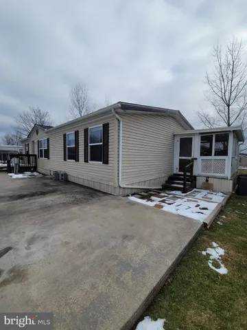 a front view of house with yard and trees in the background