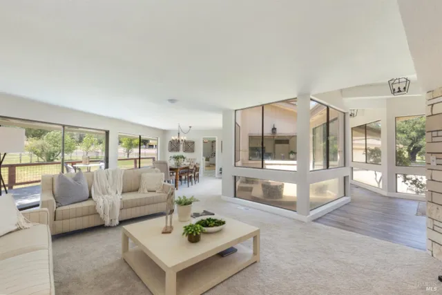 a large white kitchen with a sink a window and a glass door shower