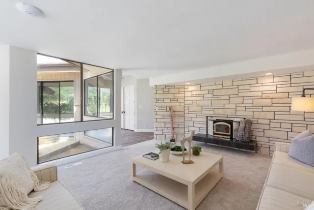 a living room with fireplace furniture and a large window