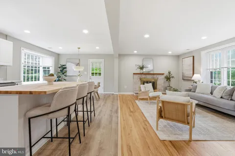 a living room with furniture a wooden floor and a large window