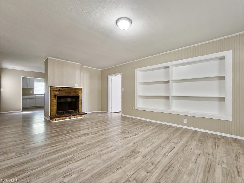 3488 Roberts Street Mims, FL 32754 - Photo 2 of 15 a view of an empty room with wooden floor fireplace and a window