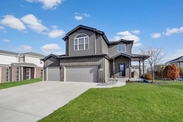 a front view of a house with a yard and garage