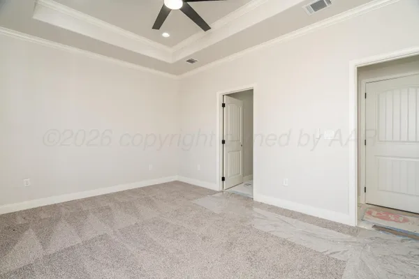 an empty room with a ceiling fan and carpet