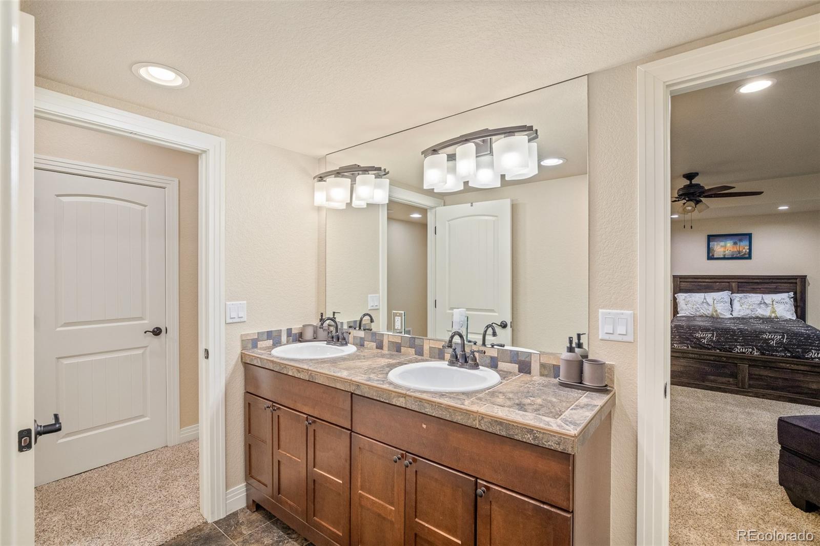 41865 East Muirfield Loop Elizabeth, CO 80107 - Photo 35 of 50 a bathroom with a double vanity sink and a mirror