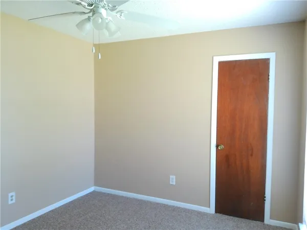 an empty room with a fan and a fan