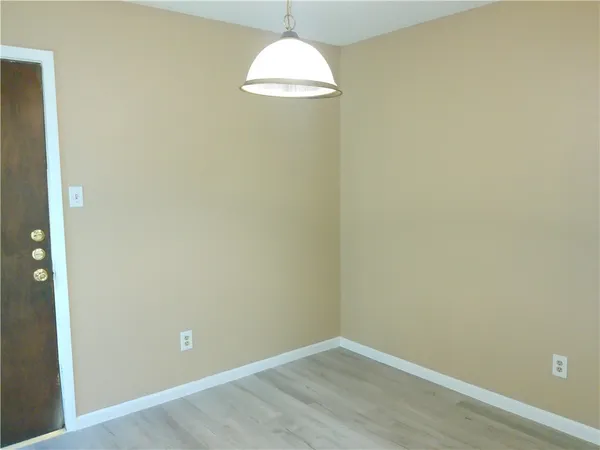 an empty room with wooden floor and a window