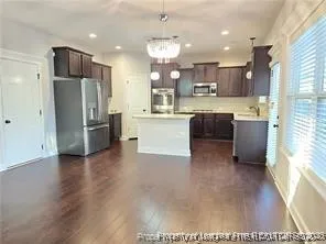a kitchen with a refrigerator and a stove top oven