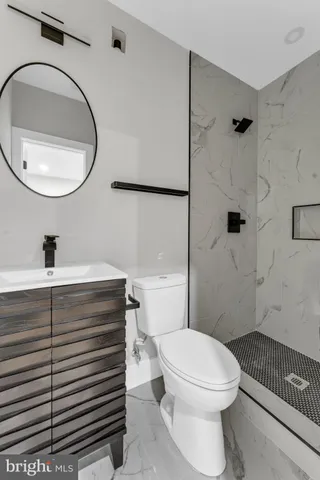 a white toilet sitting next to a bathroom sink