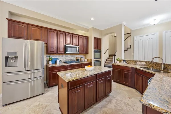 a kitchen with kitchen island granite countertop a sink and a stove