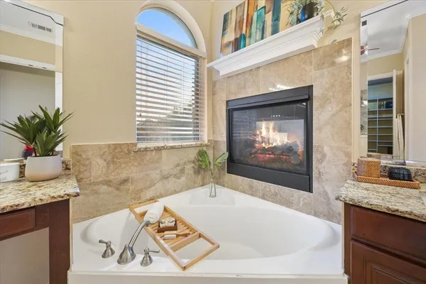 a spacious bathroom with a granite countertop sink and a bathtub