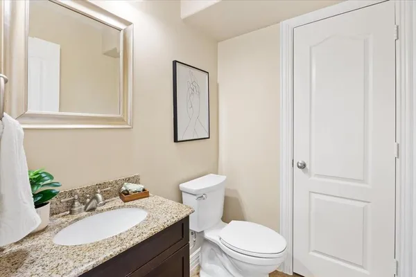 a bathroom with a granite countertop sink a toilet and shower