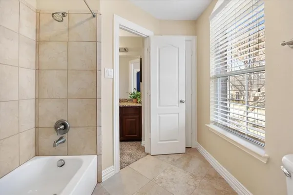 an empty room with windows and ceiling fan