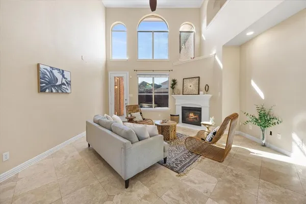 a living room with furniture a fireplace and a chandelier