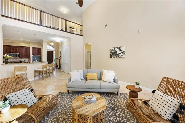 a living room with furniture wooden floor and a kitchen view