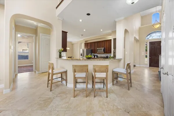 a dining hall with stainless steel appliances a dining table and chairs