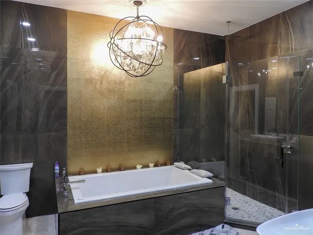 a bathroom with a sink vanity granite tub shower and a mirror
