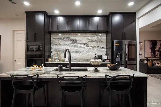 a kitchen with stainless steel appliances a sink stove and cabinets