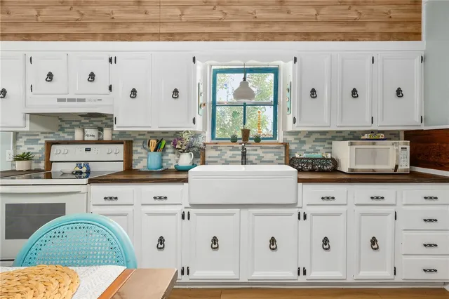 a kitchen with granite countertop white cabinets and sink