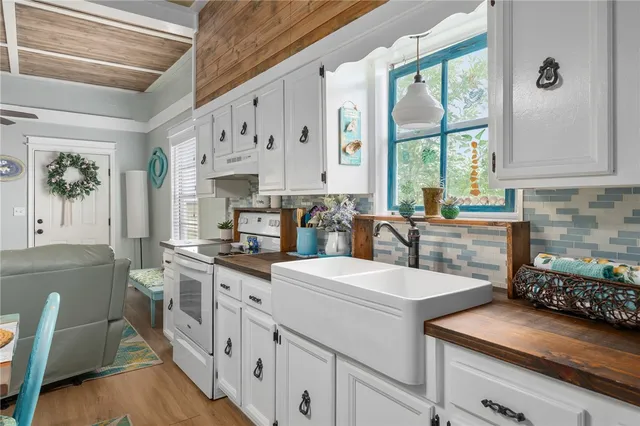 a kitchen filled with white cabinets and white appliances
