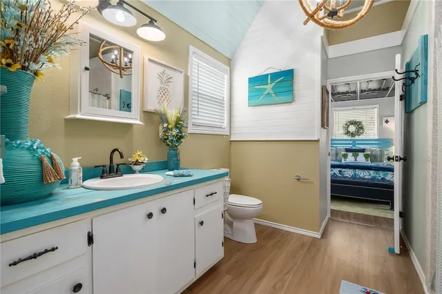 a spacious bathroom with a granite countertop sink a toilet a mirror and vanity