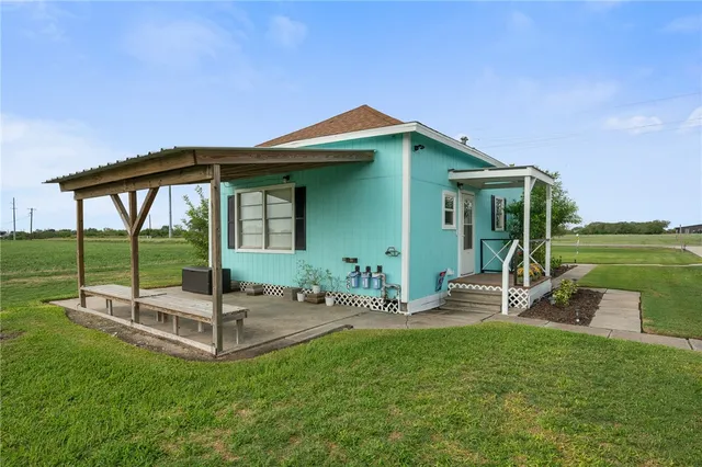 a view of a chair and table in backyard of the house