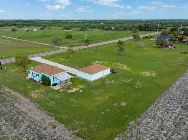 an aerial view of a houses with a yard