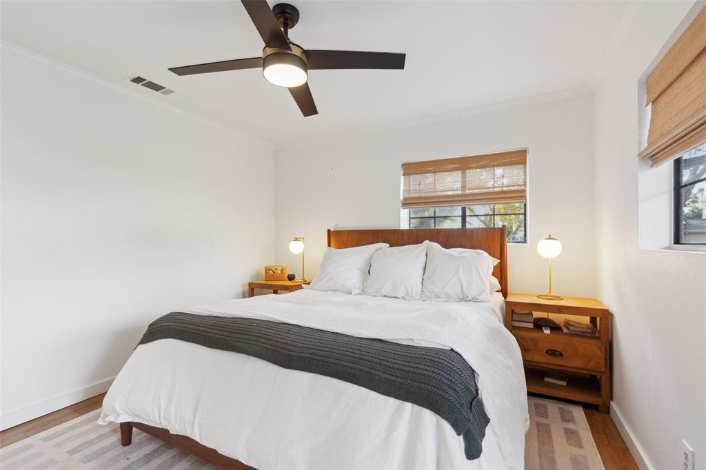 9427 Hobart Street Dallas, TX 75218 - Photo 13 of 25 a bedroom with a bed and wooden floor