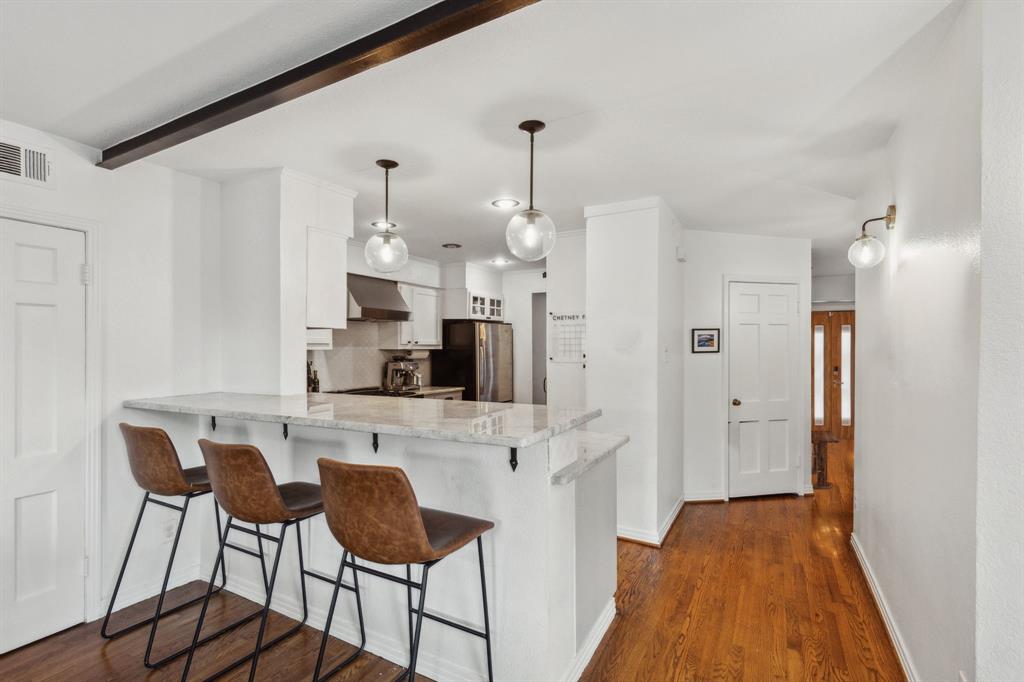 9427 Hobart Street Dallas, TX 75218 - Photo 5 of 25 a kitchen with stainless steel appliances kitchen island granite countertop a refrigerator and a stove top oven